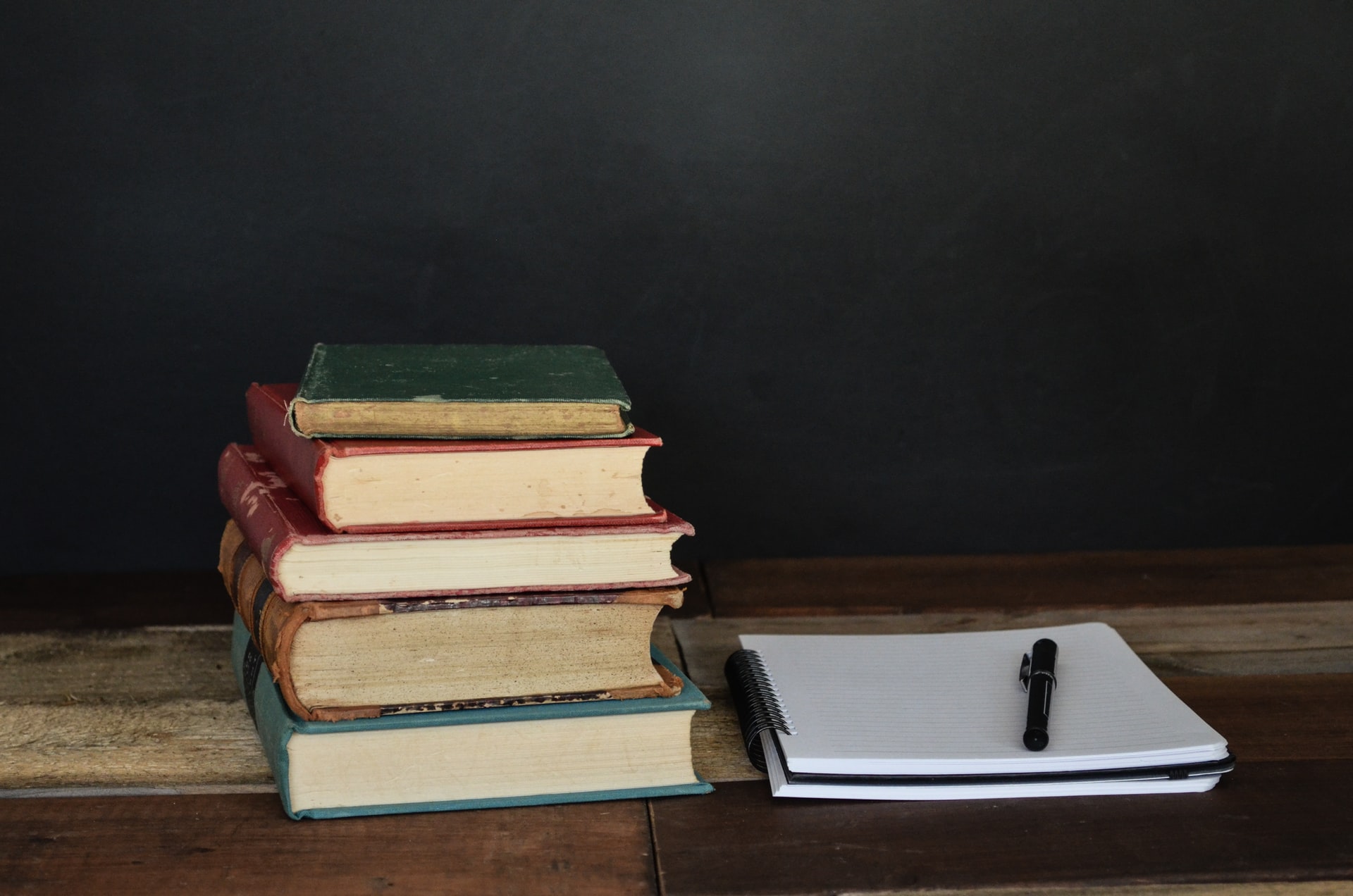 Photo of books and a notebook in front of a chalkboard by debby hudson