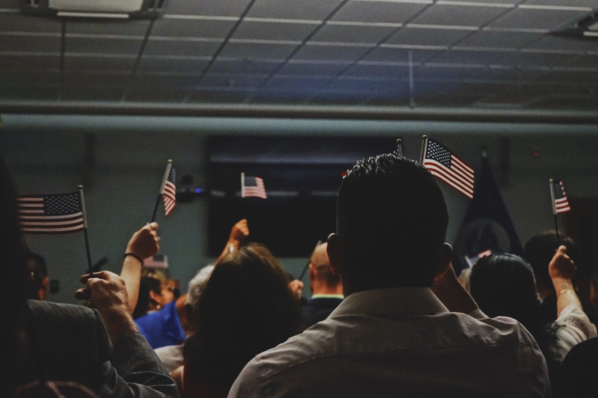 Photo of immigrant citizens holding american flags by elias castillo